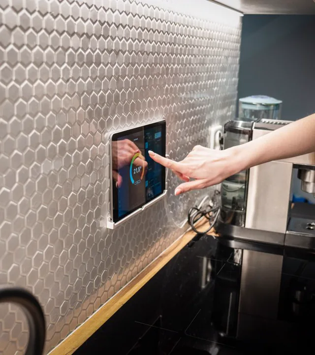 LLU TECH technician calibrating a smart home control panel in a modern luxury living room